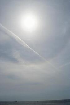 海辺の空に伸びる飛行機雲 飛行機雲,空,太陽の写真素材