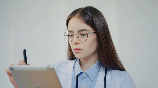 カルテをみた聴診器を身につけた眼鏡の女性 医療,予防,保険の写真素材