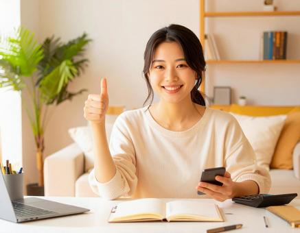 家計がうまくいきスマホ片手に微笑む女性 家計がうまくいきスマホ片手に微笑む女性の写真