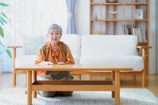 リビングで座り正面向きの高齢女性 女性,真顔,座るの写真素材