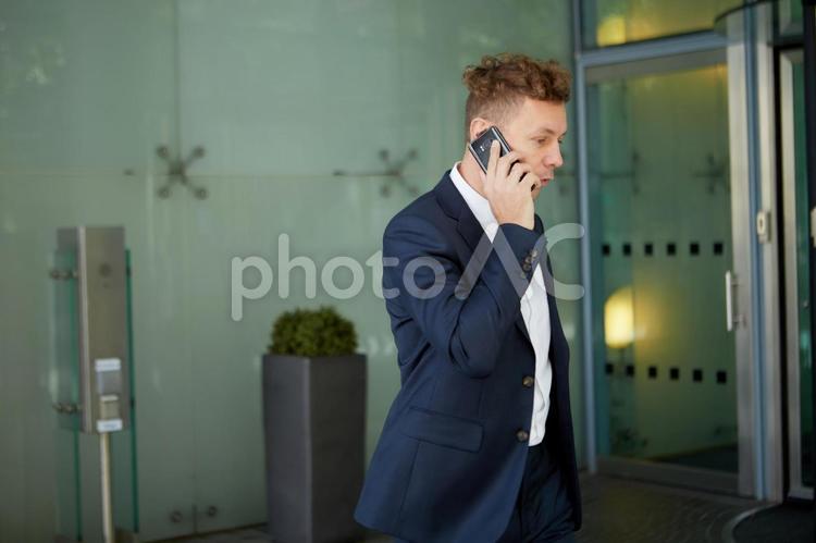 ビルの回転扉の前にいるビジネスマン1 ビジネスマン,男性,外国人の写真素材