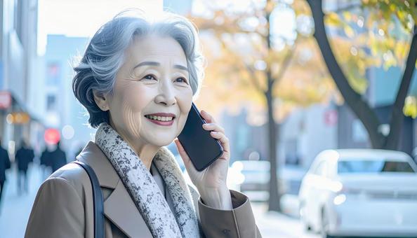 笑顔で電話する高齢者 笑顔で電話する高齢者の写真