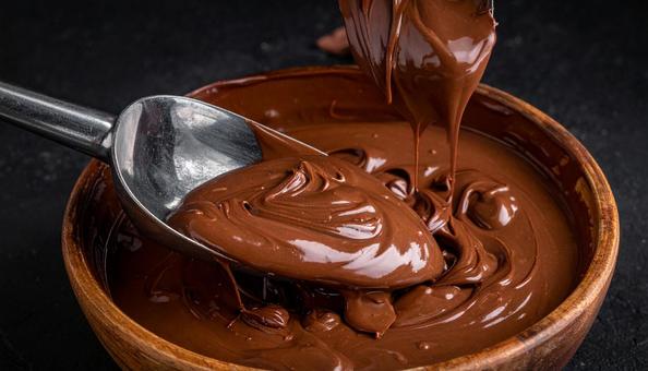 金属のスプーンと光沢のあるチョコレート 金属のスプーンと光沢のあるチョコレートの写真