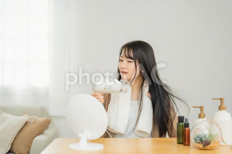 ドライヤーを使う女性 ドライヤー,ヘアードライヤー,髪の毛の写真素材