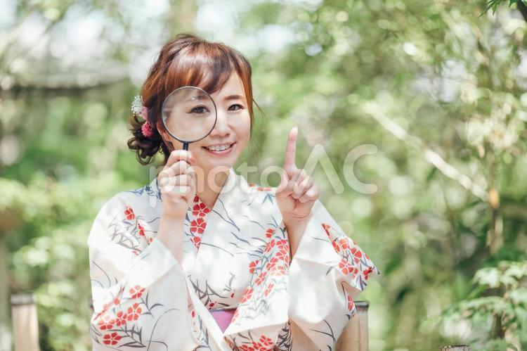 虫眼鏡を使う浴衣姿の女性 浴衣,ゆかた,検索の写真素材