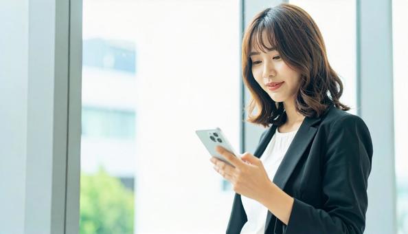 スマホを確認するビジネス女性 スマホを確認するビジネス女性の写真
