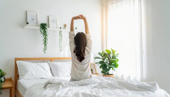 寝起きにストレッチをする日本人女性の写真