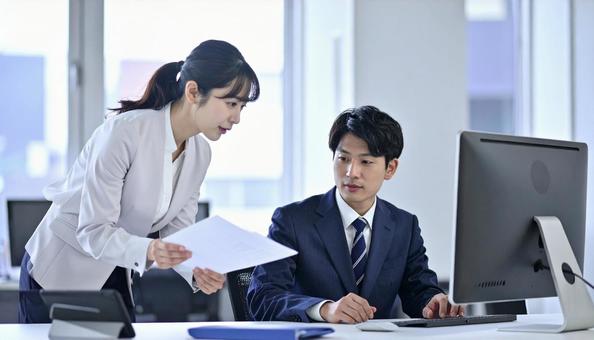 上司に資料を確認する女性社員 上司に資料を確認する女性社員の写真