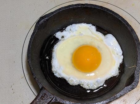 IHコンロ上でスキレットで焼く玉子焼き 目玉焼き,ベイクドエッグ,鋳鉄製フライパンの写真素材