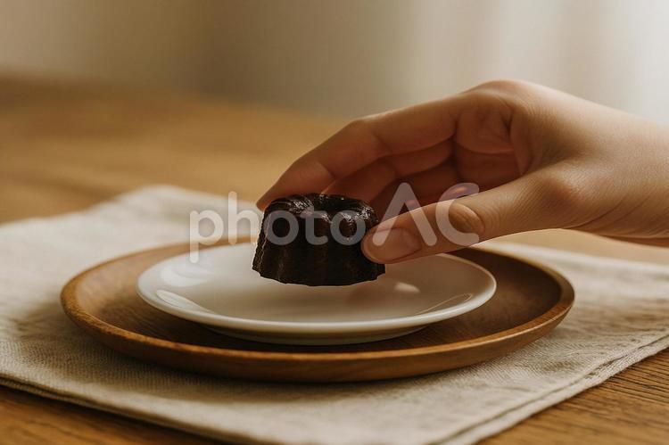 カヌレをつまみ上げる手元 カヌレ,手元,小皿の写真素材