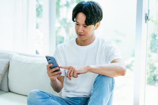 スマホを操作する男性 スマホを操作する男性 スマホ,笑顔,男性の写真素材