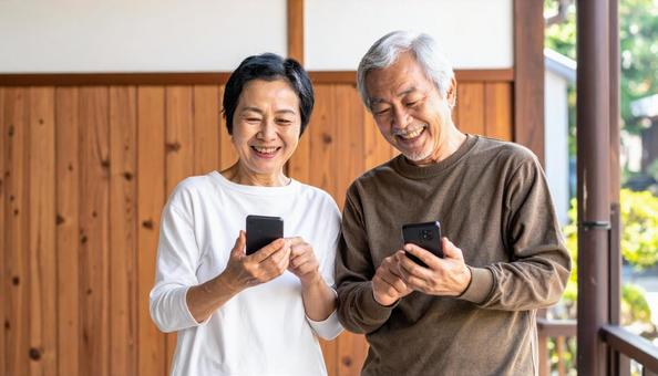 スマホを楽しむシニア夫婦 スマホを楽しむシニア夫婦の写真