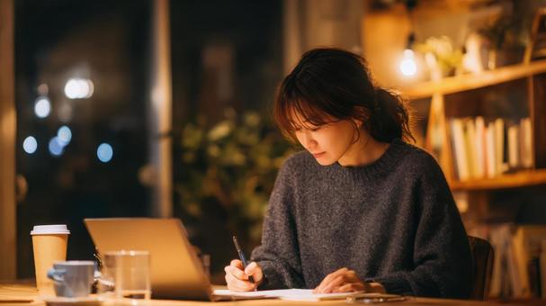 夜に在宅ワークに取り組む女性 夜に在宅ワークに取り組む女性の写真