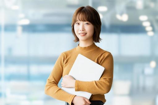 パソコンを持つ女性・ビジネスウーマン パソコンを持つ女性・ビジネスウーマン 女性,パソコン,笑顔の写真素材