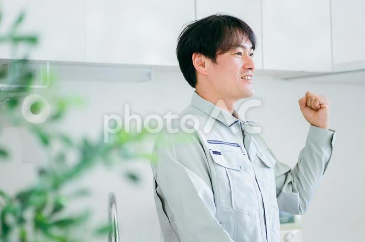 キッチンと作業着姿の男性 工務店,作業服,設備の写真素材