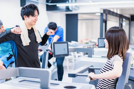 ジムでトレーナーの指導を受ける若い女性 オリエンテーション,健康産業,使い方の写真素材