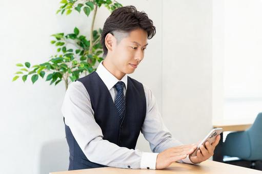 オフィスでスマホを使う男性ビジネスマン オフィスでスマホを使う男性ビジネスマン 男性,スマホ,スマートフォンの写真素材