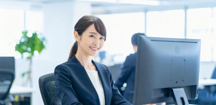 オフィスでパソコン使用した仕事をする女性 オフィスでパソコン使用した仕事をする女性の写真
