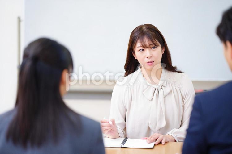 三者面談する塾講師の女性と生徒とお父さん 塾,人物,女の子の写真素材