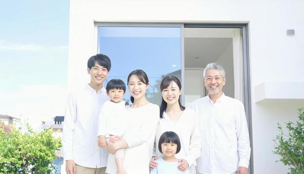 家の玄関前で記念撮影する三世代家族 家の玄関前で記念撮影する三世代家族の写真