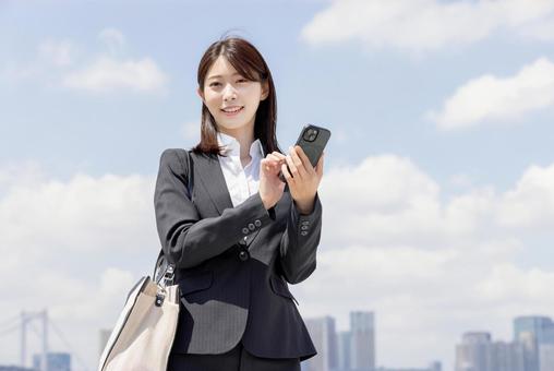 スマートフォンで調べるビジネスウーマン スマートフォンで調べるビジネスウーマン 女性,スマートフォン,スマホの写真素材