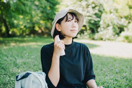 日焼け止めスプレーを塗る女性 日焼け止めスプレーを塗る女性 日焼け止め,日焼け止めクリーム,日焼け止めスプレーの写真素材