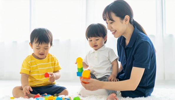 笑顔の保育士と遊ぶ子どもたち 笑顔の保育士と遊ぶ子どもたちの写真