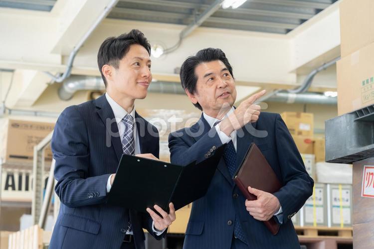 倉庫で会議をするミドルのビジネスマン 倉庫,会議,工場の写真素材
