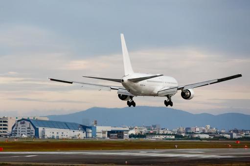 着陸する旅客機｜伊丹空港｜曇り空 飛行機,着陸,滑走路の写真素材