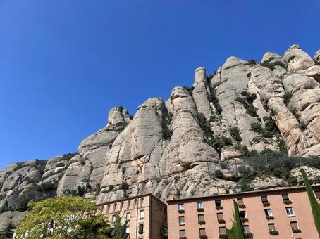 モンセラット奇岩群と赤褐色の建物 バルセロナ,スペイン,カタルーニャの写真素材