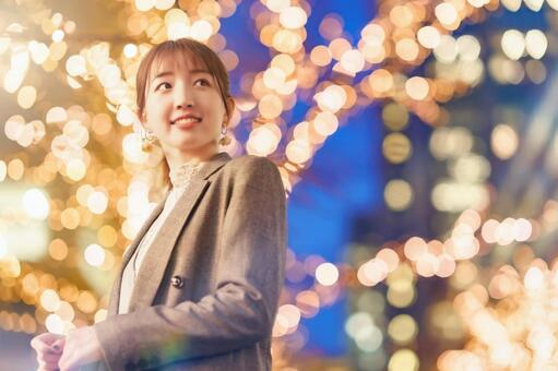 街なかのイルミネーションを楽しむ若い女性  ポートレート,女性,イルミネーションの写真素材