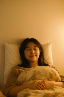 リラックスできる睡眠環境で眠る女性 リラックスできる睡眠環境で眠る女性の写真
