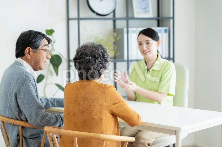 シニアの夫婦に説明するケアマネジャー 介護,相談,カウンセリングの写真素材