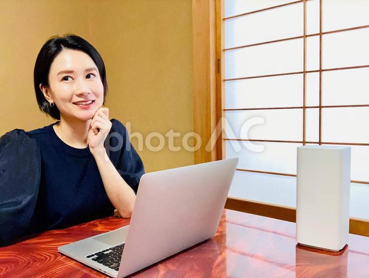 和室でリモートワークをする笑顔の女性 在宅ワーク,wifi,パソコンの写真素材