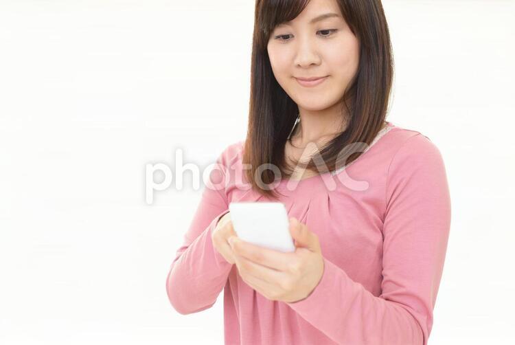 スマートフォンを持つ笑顔の女性 女性,スマートフォン,女の写真素材