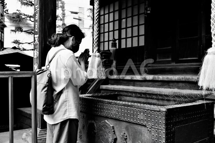 布袋尊を参拝する女性：白黒 女性,マスク姿,白黒の写真素材