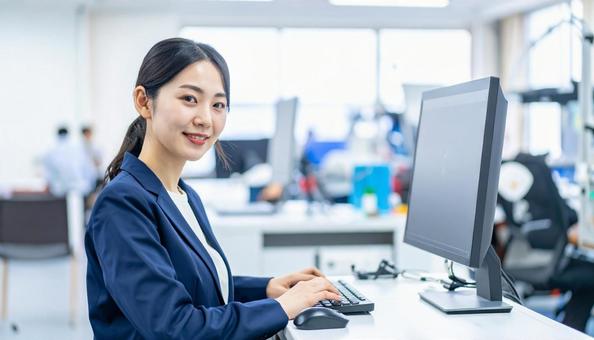 工場の三次元測定機を使う作業服の女性 工場の三次元測定機を使う作業服の女性の写真