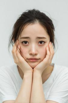 悩みを抱えるような表情の若い日本人女性 悩みを抱えるような表情の若い日本人女性の写真