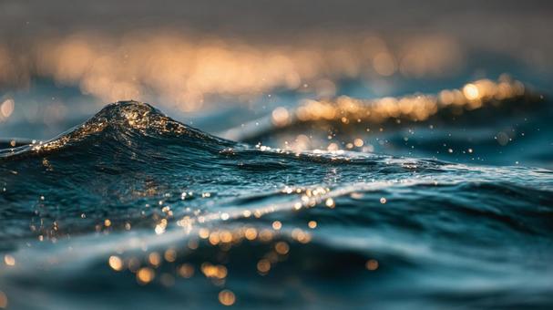 穏やかな波と水面に反射する光 穏やかな波と水面に反射する光の写真