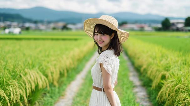 田園風景の道を歩くワンピース姿の女性 田園風景の道を歩くワンピース姿の女性の写真