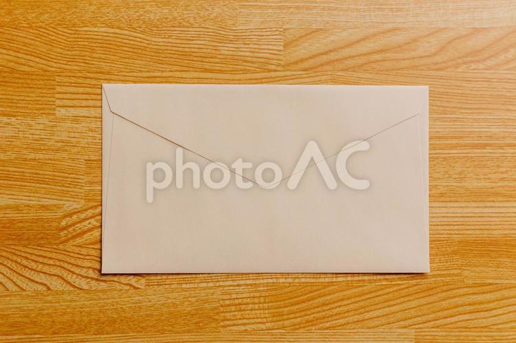 机に置かれたベージュの封筒 封筒,手紙,レターの写真素材