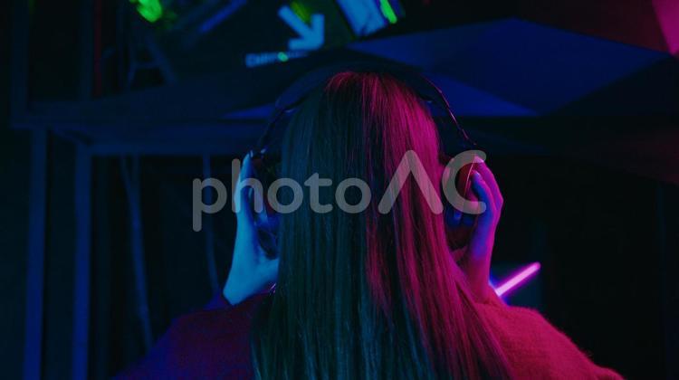 ヘッドセットをおさえる女性の後ろ姿のアップ ゲーム,ゲーマー,人物の写真素材