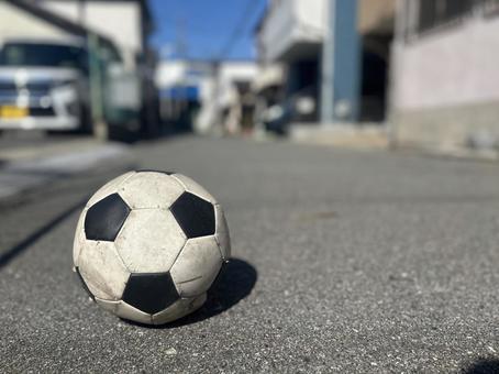 住宅街の道に転がっているサッカーボール 住宅街の道に転がっているサッカーボールの写真
