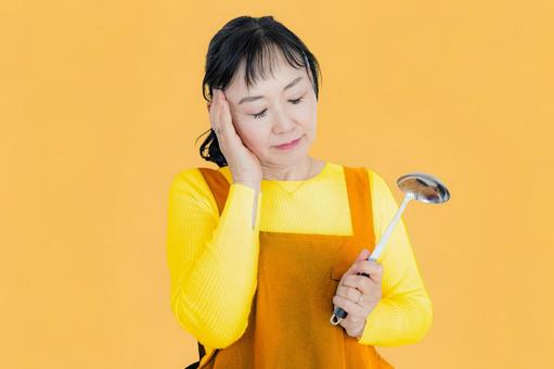 辛そうなお母さん 女性,悩む,エプロンの写真素材