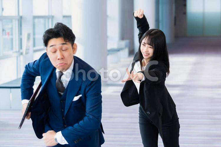 ふざけて逃げる上司を殴ろうとする女性部下 ビジネスウーマン,ビジネスマン,女性の写真素材