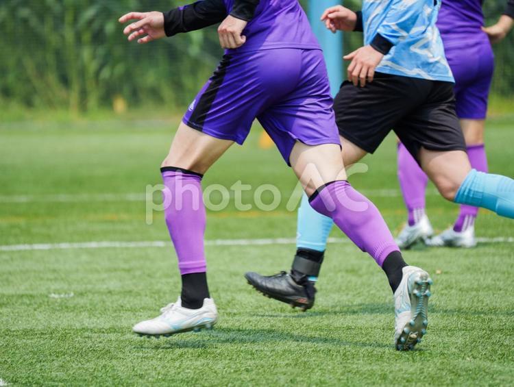 サッカー　走る　躍動感　芝生　部活　大会 ドリブル,シュート,紫のユニフォームの写真素材