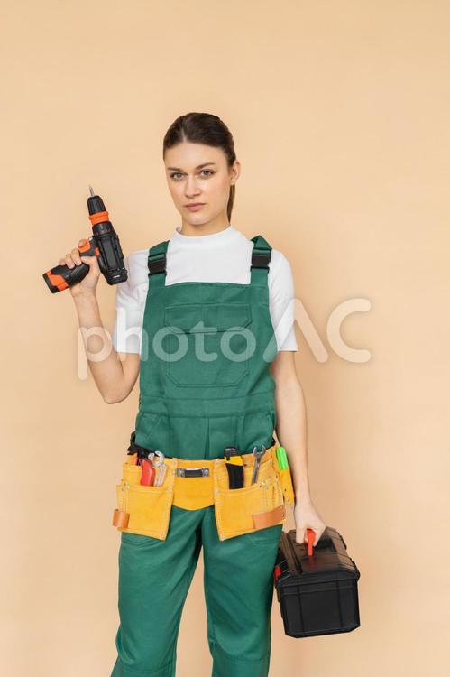 カメラ目線で電動工具や工具箱を持つ女性 女性,工具箱,電動工具の写真素材