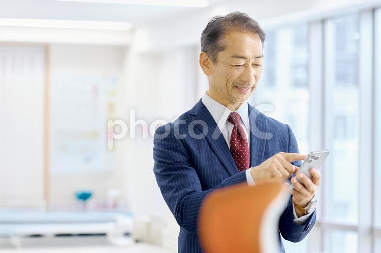 スマホを見るビジネスマン　ミドル　経営者 ビジネスマン,スマホ,ミドルの写真素材