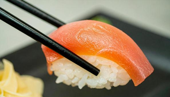皿に盛られた美味しそうな寿司を箸でつまむ 皿に盛られた美味しそうな寿司を箸でつまむの写真