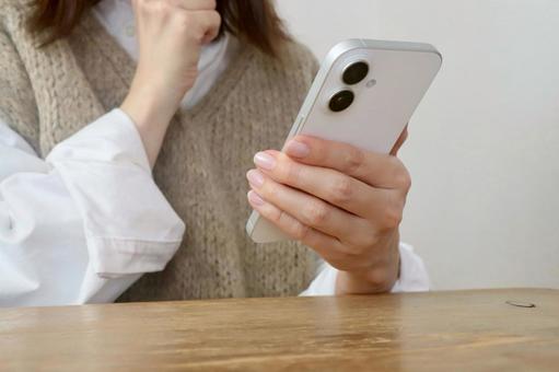 スマホを見ながら考える女性 スマホ,女性,考えるの写真素材